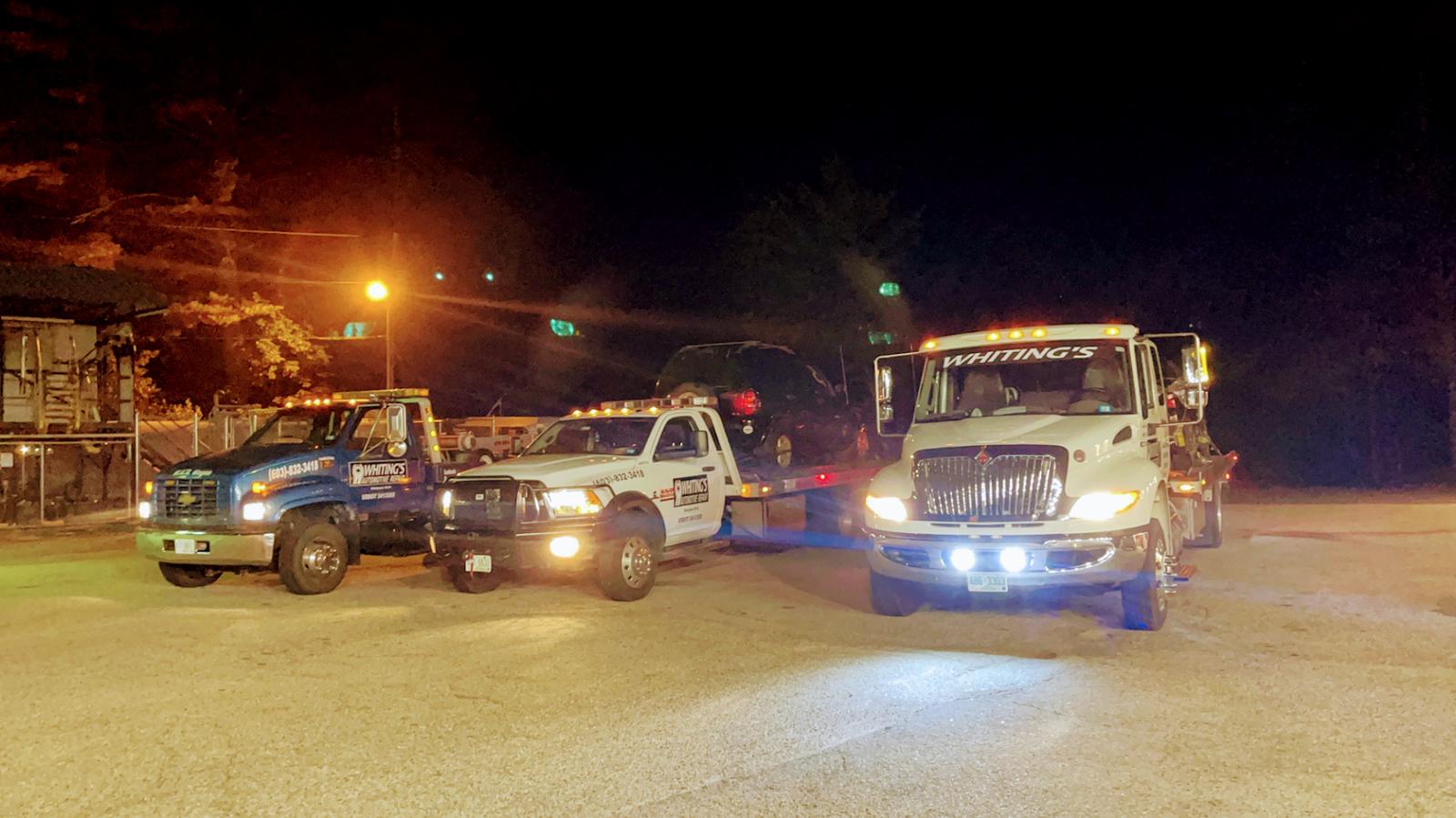 Whiting's tow trucks lined up at night — Ossipee, NH