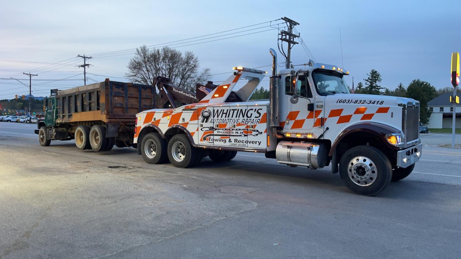 Whiting's wrecker towing a dump truck at dusk