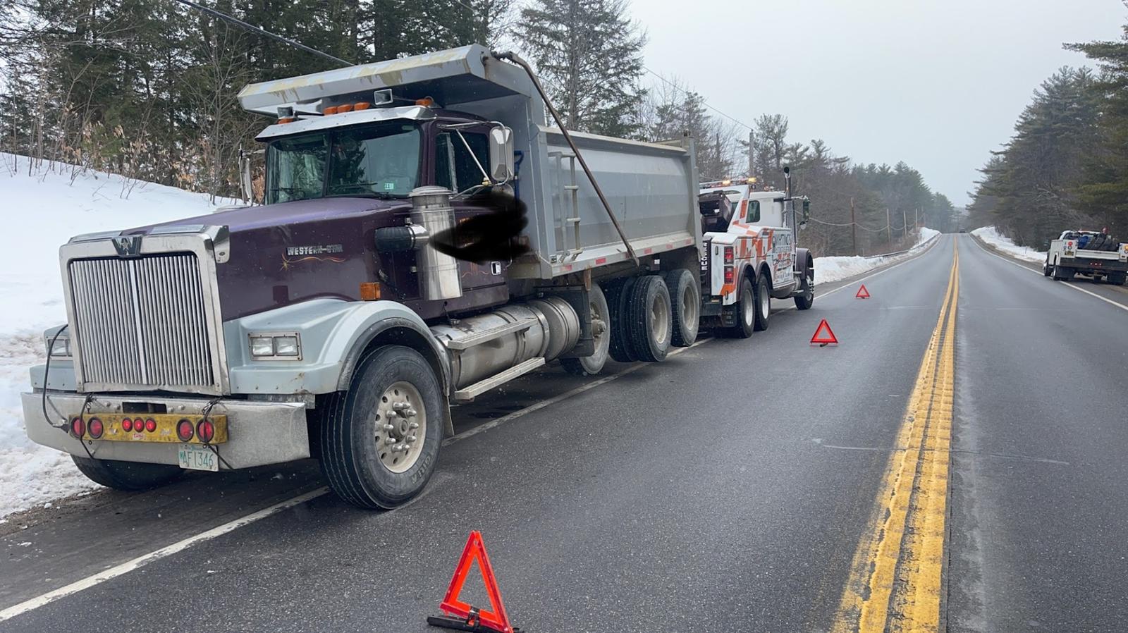 Whiting's heavy wrecker towing a Western Star dump truck on a snowy road