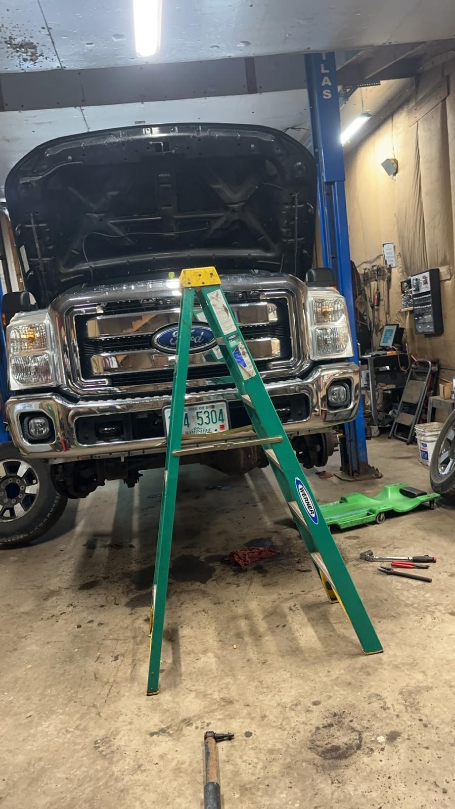 A Ford Super Duty up on the two-post lift in Whiting's repair bay